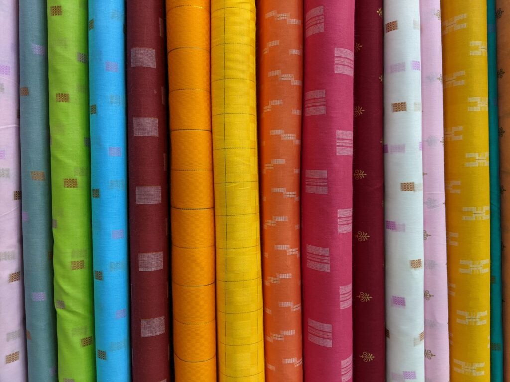 A vivid array of assorted fabric rolls showcasing diverse patterns and colors for creative projects.