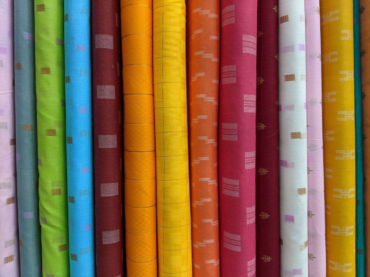 A vivid array of assorted fabric rolls showcasing diverse patterns and colors for creative projects.